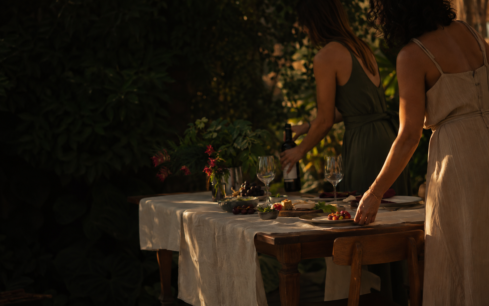 Duas mulheres preparando uma mesa para um encontro com vinho